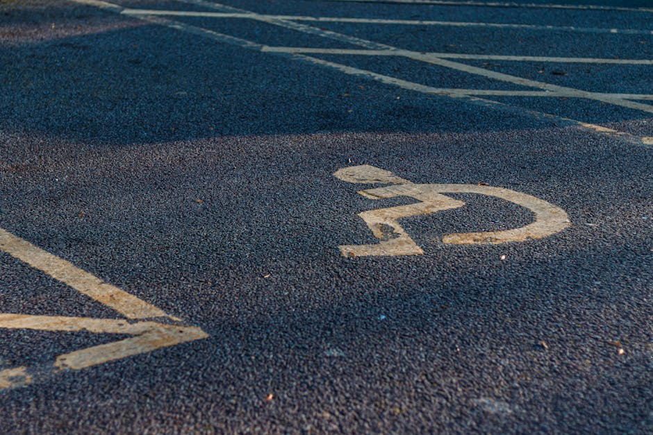 Close-up view of a marked parking space numbered '22' on an asphalt surface in an outdoor parking lot. The parking spot outline is painted in white, and the number is centered within the space. The su